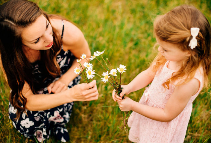 mom and daughter picking wildflowers