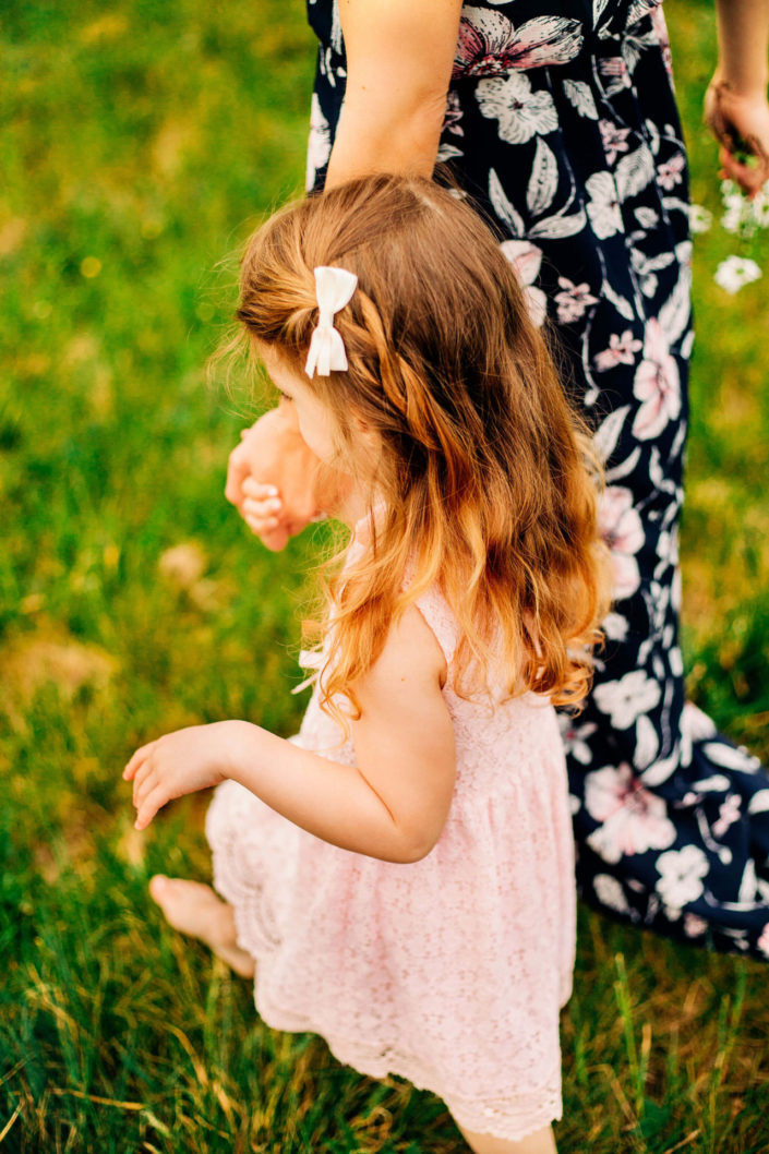 mom holding daughter's hand while walking