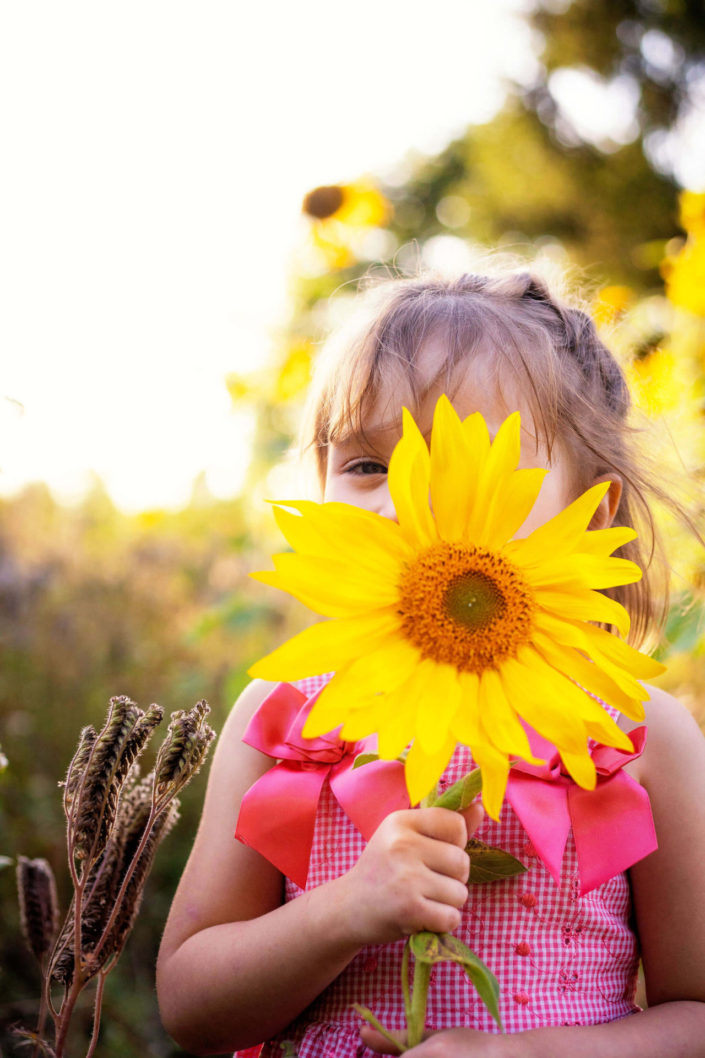 little girl holding a sunflower