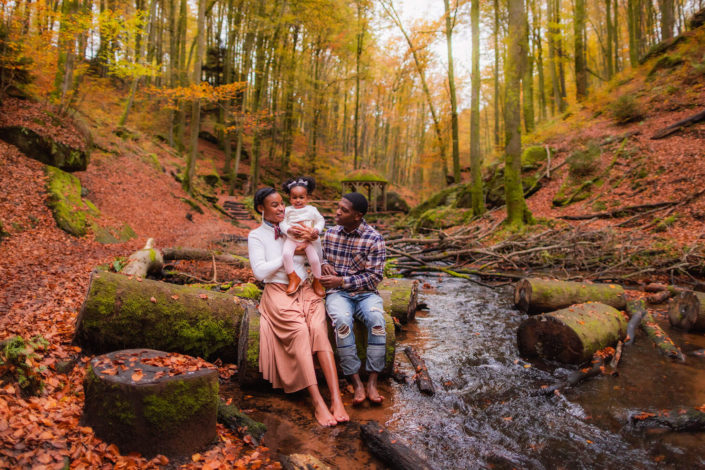 family sitting by the river on a fall day