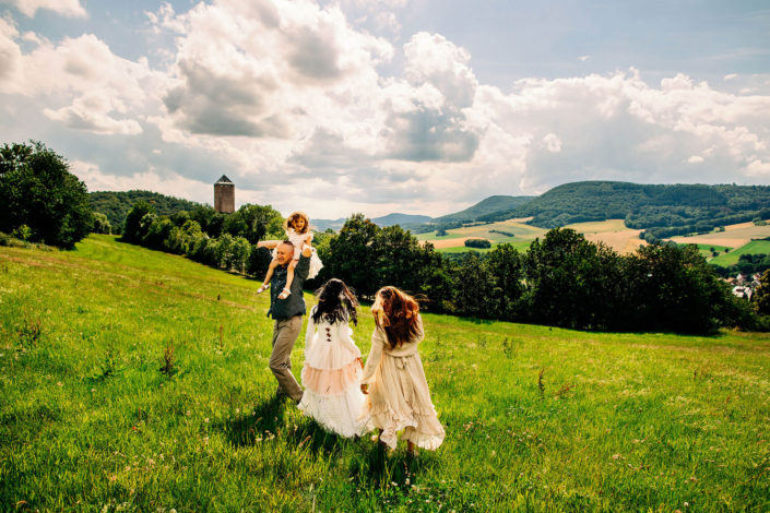 Family picture in the rolling hills of Germany with castle in the background